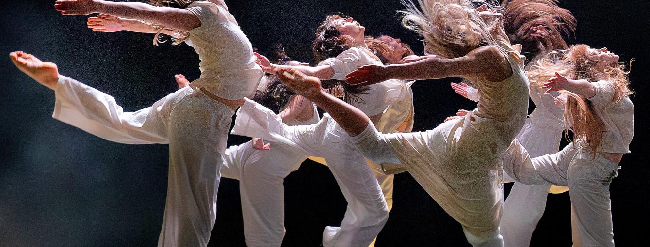 Dancers on stage jump in the air