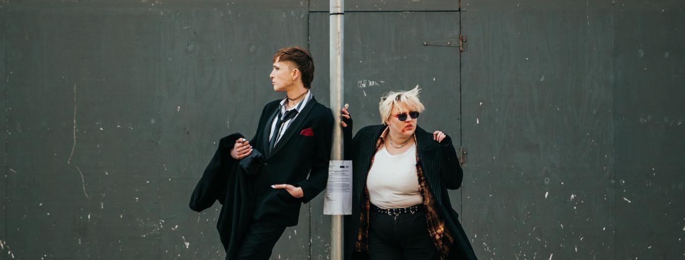 Two goths standing at a bus stop